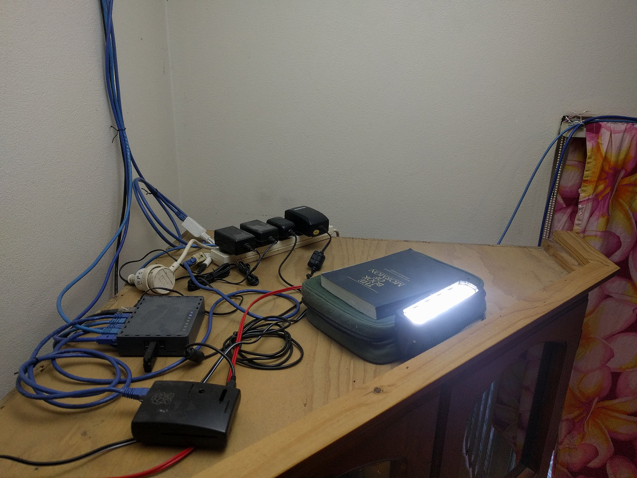 The floodlight sits next to my router and pi-hole, propped up with some books.