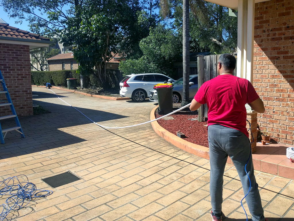 Skilled ISP Technicians (aka My Neighbours) Doing the Cable Run. That's 100m of Cat6 Ethernet Cable on the Left.